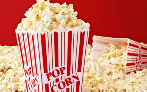 Overflowing Popcorn Box Red Background Wallpaper