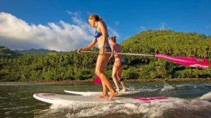 Paddleboarder Enjoying A Serene Ride On The Calm Water Wallpaper