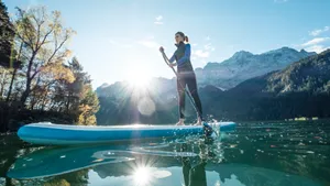 Paddleboarder Gliding Across Calm Turquoise Waters On A Sunny Day Wallpaper