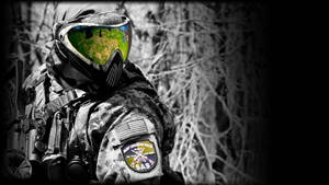 Paintball Pro Clad In Full Gear With Helmet During An Exciting Match. Wallpaper