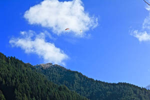 Paragliding Over Steep Mountains Wallpaper