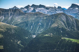 Paragliding Over Verdant Mountain Ranges Wallpaper