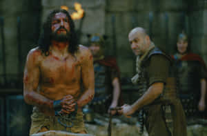 Passion Of Christ_ Bloodied Man In Chains Wallpaper