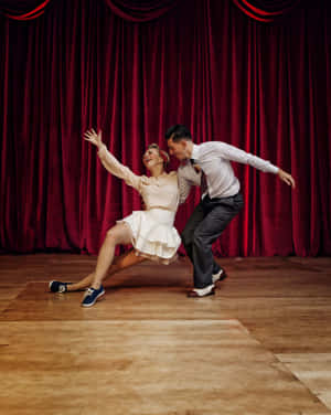 Passionate Swing Dancers In Rhythmic Motion Wallpaper