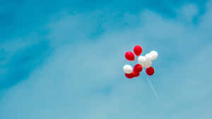 Patriotic Balloons Against Blue Sky Wallpaper