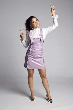 Peace Sign Posing Womanin Purple Dress Wallpaper