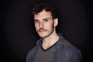 Pensive Sam Claflin Posing For A Photo Shoot Wallpaper