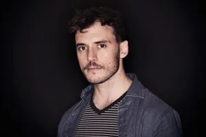 Pensive Sam Claflin Posing For A Photo Shoot Wallpaper