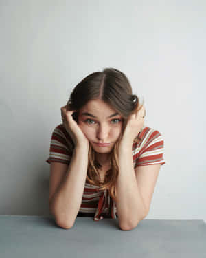 Pensive Woman Leaningon Table Wallpaper