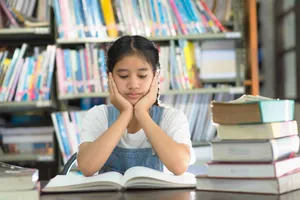 Pensive Young Girl In Library Wallpaper