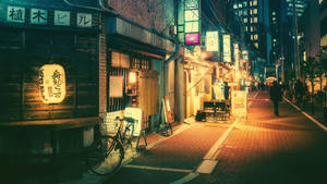 People Walking Through A Shopping District In Tokyo. Wallpaper