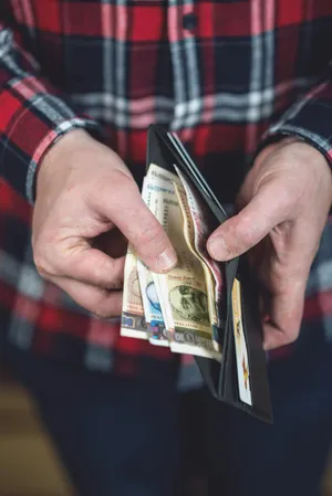 Person Holding Open Wallet With Cashand Cards Wallpaper