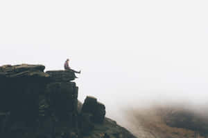 Person Sitting Along On Cliff Ledge Wallpaper