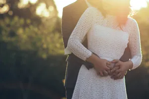 Photo Of A Couple's Tangible Hug Wearing White Dress And Black Suit Wallpaper