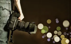 Photographer Holding Camera Bokeh Background Wallpaper