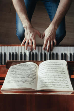 Pianist Hands Over Keys With Sheet Music Wallpaper