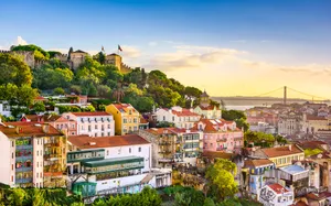 Picturesque View Of Hillside Homes Amidst Lush Greenery In Lisbon Wallpaper