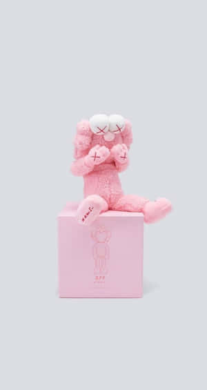 Pink Kaws Figure Seatedon Box Wallpaper