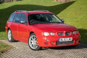 Polished Silver Mg Zt Luxury Sports Sedan Parked Outside Wallpaper