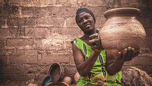 Poor African Woman Holding Jar Wallpaper