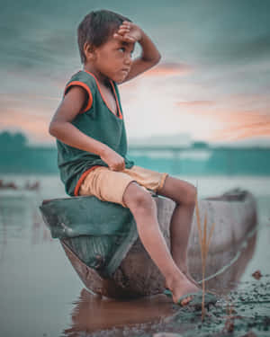 Poor Boy Sitting On A Canoe Wallpaper