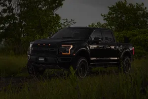 Powerful Ford Raptor With Vibrant Orange Headlights Shining In The Dark Wallpaper