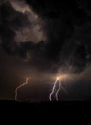 Powerful Lightning Strikes A Dark Night Sky. Wallpaper