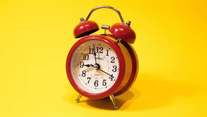 Precise Red Alarm Clock Displaying Time Wallpaper