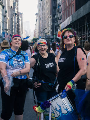 Pride And Unity: Group Of Lesbian Women Marching On The Street Wallpaper