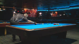 Professional Billiards Player In Action On A Vibrant Blue Pool Table. Wallpaper