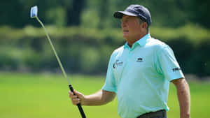 Professional Golfer Fred Funk Analyzing His Golf Club During A Tournament. Wallpaper