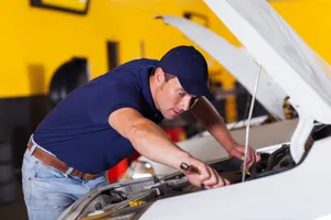 Professional Mechanic Fixing A Car At The Auto Repair Shop Wallpaper