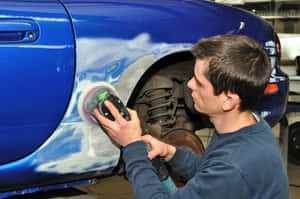 Professional Mechanic Performing Car Repair In Garage Wallpaper