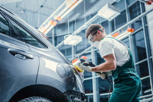 Professional Mechanic Repairing A Car In A Garage Wallpaper
