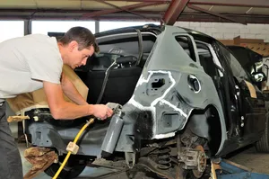 Professional Mechanic Repairing Car At An Auto Repair Shop Wallpaper