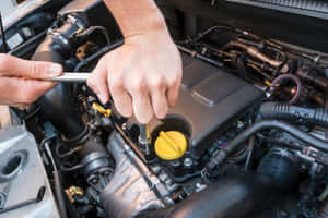 Professional Mechanic Working On A Damaged Car Wallpaper