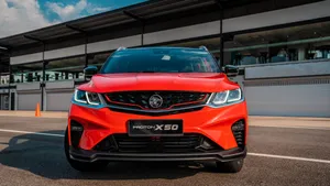 Proton Supercar On A City Street At Night Wallpaper