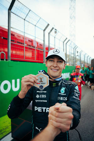 Proud Moment With George Russell Holding A Medal Wallpaper