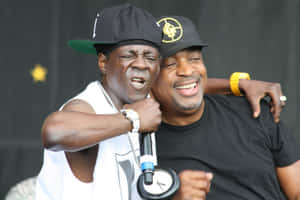 Public Enemy Members Embraceon Stage Wallpaper