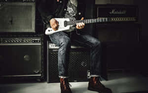 Punk Guitarist Amidst Amplifiers.jpg Wallpaper