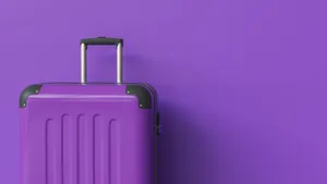 Purple Suitcase Against Matching Background Wallpaper