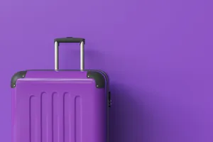 Purple Suitcase Against Matching Background Wallpaper