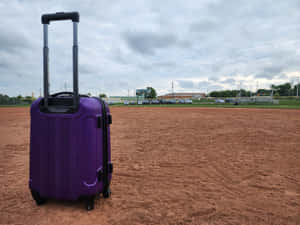 Purple Suitcaseon Red Dirt Field Wallpaper