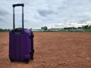 Purple Suitcaseon Red Dirt Field Wallpaper