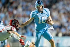 Quarterback Evading Tackle During Game Wallpaper