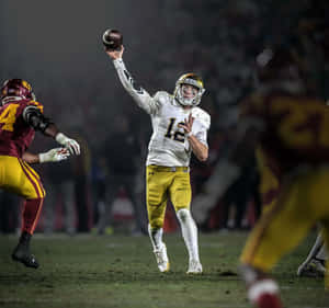 Quarterback Throwing Football During Game Wallpaper