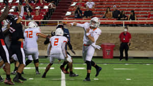 Quarterback Throwing Football During Game Wallpaper