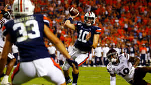 Quarterback Throwing Football During Game Wallpaper