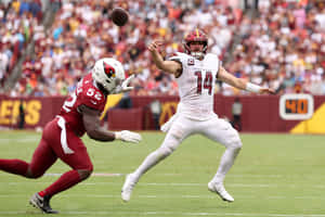 Quarterback Throwing Football During Game Wallpaper