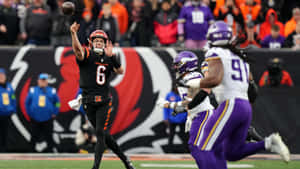 Quarterback Throwing Football During Game Wallpaper